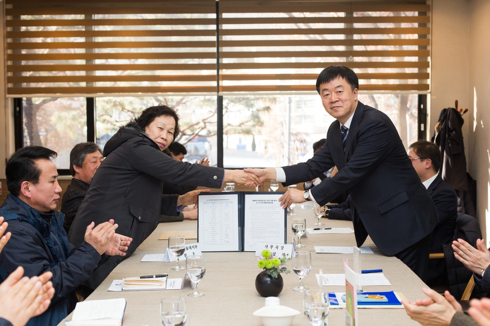 학내 청소·경비 노동자가 소속된 일반노조 서울대분회 최분조 분회장(왼쪽)과 성삼제 서울대 사무국장(오른쪽)이 지난 6일 서울대 호암교수회관에서 서울대학교 용역·파견근로자의 정규직 전환에 합의하며 악수를 하고 있다. 서울대학교 제공