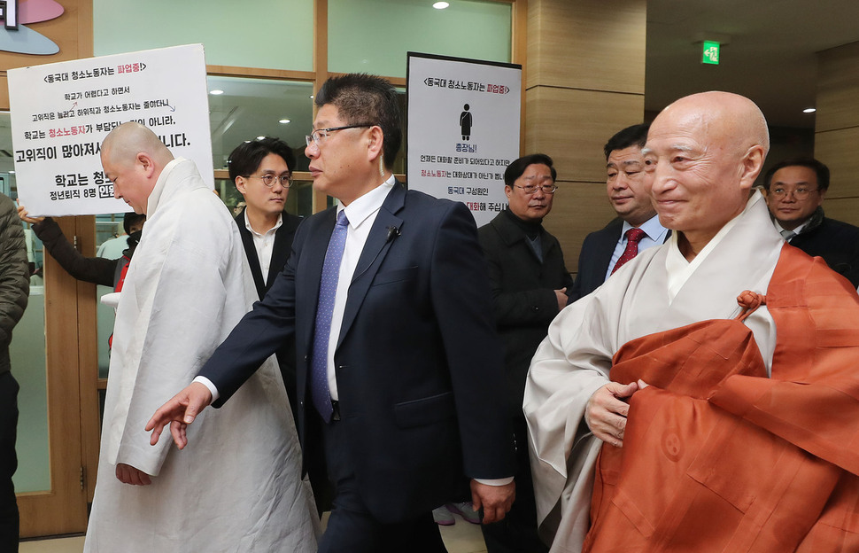 설정 조계종 총무원장이 20일 오전 서울 중구 필동 동국대에서 청소노동자들이 손팻말 시위를 하는 곳 앞으로 지나가고 있다. 신소영 기자