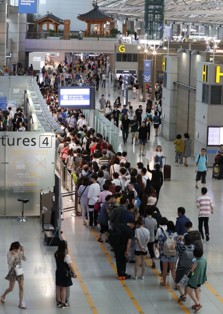 지난해 7월 휴가철을 맞은 시민들이 인천공항 출국장에 늘어서 있다. 한겨레 자료사진