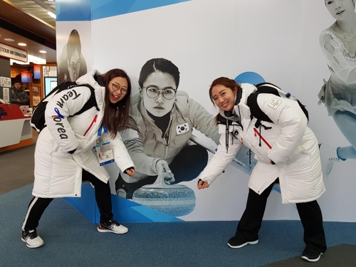 여자컬링 대표팀 김선영과 김영미가 김은정 사진 앞에서 장난을 치고 있다. 사진 찍은 장소는 2018 평창동계올림픽 코리아하우스. 김민정 감독 제공