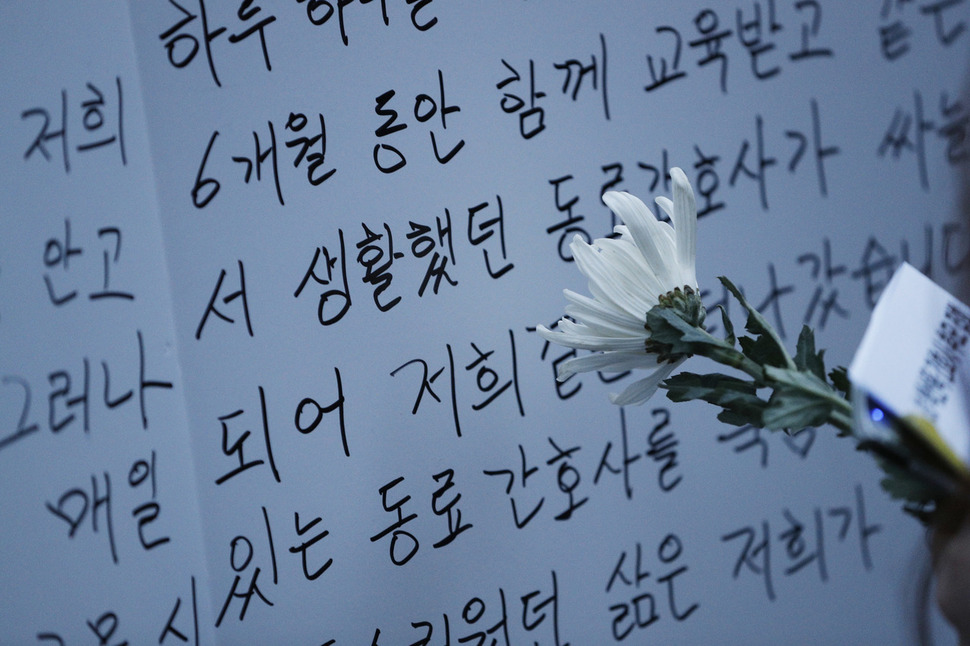 한 참가자가 든 조화 뒤로 태움 근절 촉구에 대해 간호사들이 쓴 대자보가 보이고 있다. 이정아 기자 leej@hani.co.kr