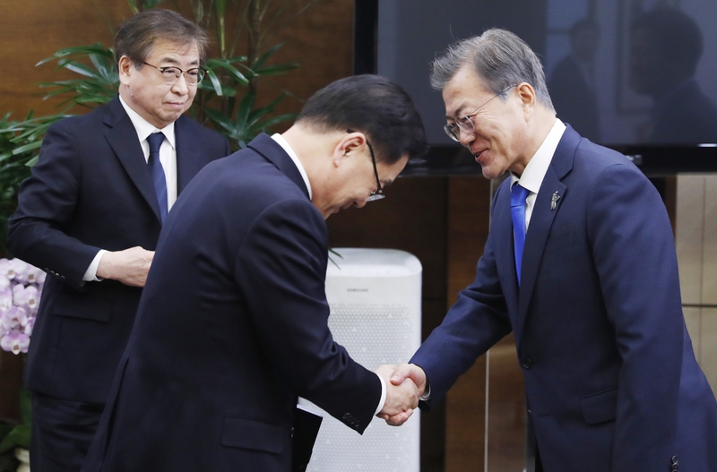 문재인 대통령이 6일 오후 청와대에서 대통령 특사로 북한을 방문하고 돌아온 정의용 국가안보실장과 악수하고 있다. 맨 왼쪽은 서훈 국정원장. 청와대 제공