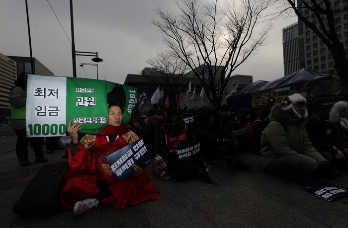 지난 1월30일 오후 서울 세종로 정부서울청사 앞에서 ‘최저임금 인상 무력화 규탄, 최저임금제도 개악 저지 민주노총 결의대회’가 열려, 한 참가자가 최저임금 인상을 무력화려는 시도를 풍자하며 분장을 하고 앉아 있다. 박종식 기자 anaki@hani.co.kr