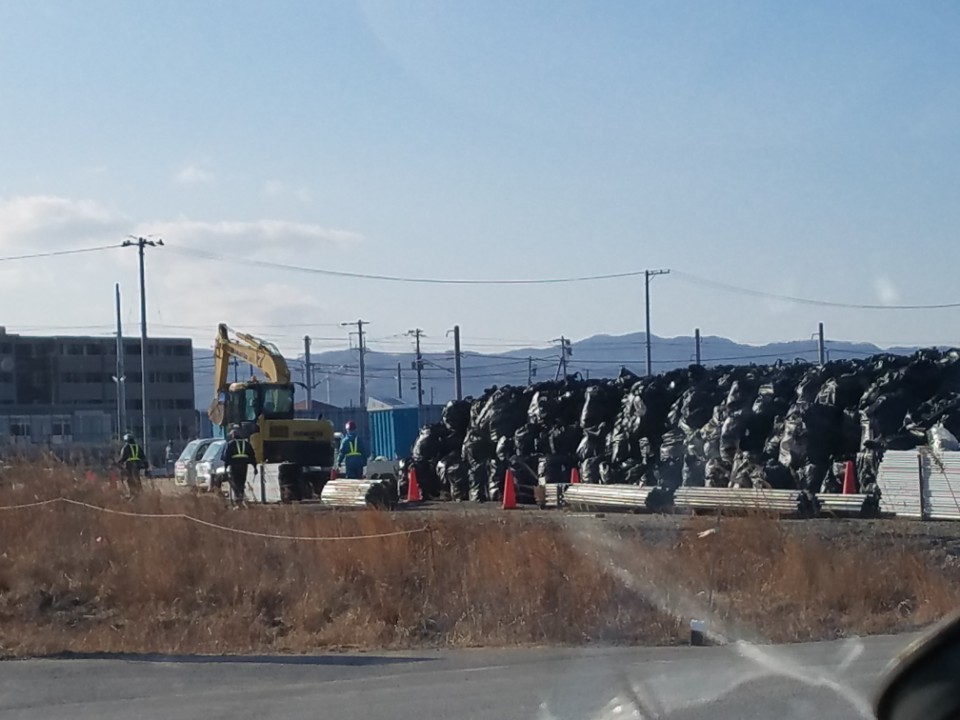 6日福島県双葉だねドミオカジヨックに放射能廃棄物積み置き場と作業員が見える.