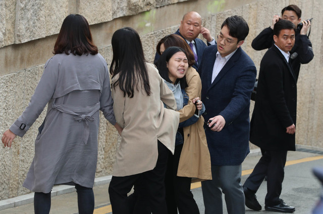 이명박 전 대통령이 탄 차량이 14일 오전 서울 논현동 이 전 대통령 집을 출발해 서초동 서울중앙지검으로 향하자 집 앞에서 1인시위를 하던 민중민주당 당원이 구호를 외치고 있다. 김정효 기자