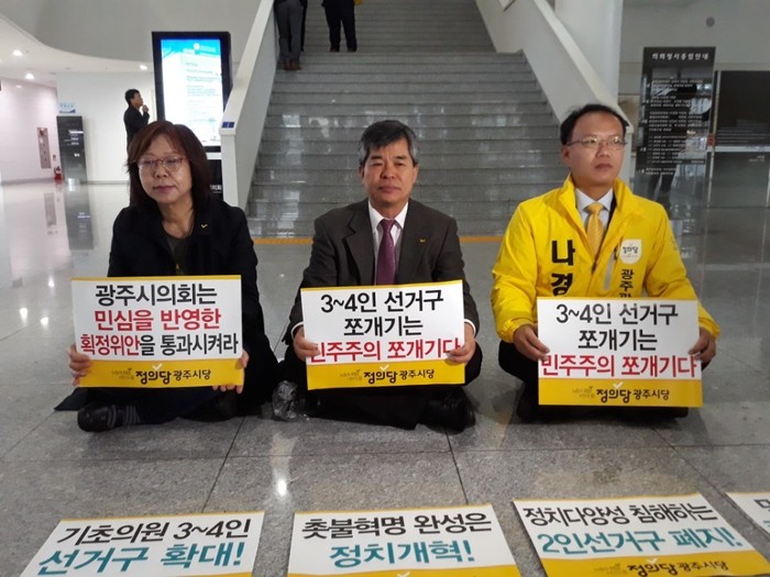 정의당 광주시당 소속 당원들은 15일 광주시의회 로비에서 ‘3~4인 선거구 쪼개기는 민주주의 쪼개기’라고 적힌 팻말을 들고 농성에 들어갔다. 정대하 기자
