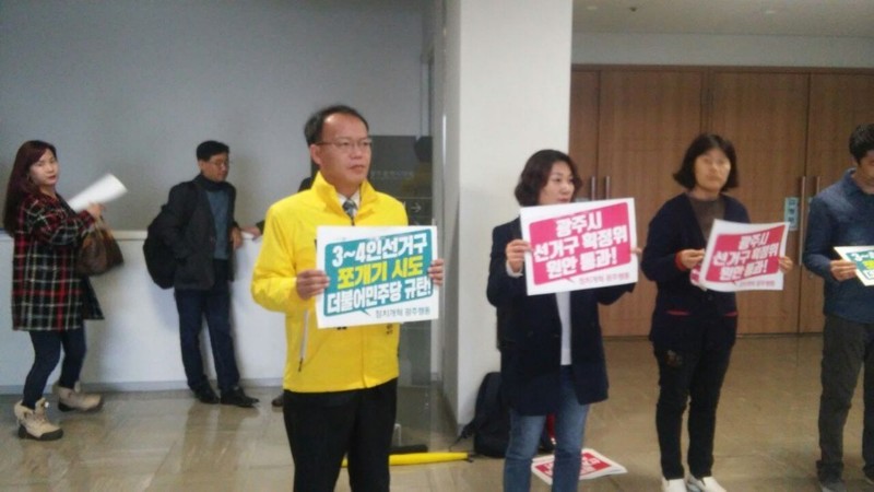 정의당 광주시당 소속 당원들이 19일 오전 광주시의회 앞에서 3~4인 선거구를 쪼개지 말라는 내용이 적힌 팻말을 들고 있다. 정의당 제공