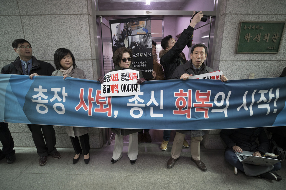 교비횡령 및 입시비리 등의 혐의를 받고 있는 김영우 총신대 총장과 관련해 실태조사를 나온 교육부 직원이 20일 오후 서울 동작구 총신대 평생교육원 회의실에서 학교 쪽과 면담을 시작하자, 교수들이 회의실 입구를 향해 ‘총장사퇴’가 적힌 펼침막을 들고 있다. 김성광 기자