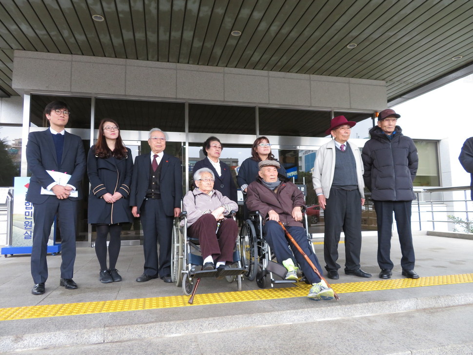 제주 4·3 사건 수형인들이 제주지법 형사2부(재판장 제갈창)의 심리로 19일 오후 2시 열린 재심 청구 사건 심문기일에 출석하기 전 법원 앞에서 기자회견을 열고 있다. 왼쪽부터 법무법인 해마루의 임재성·김세은 변호사와 재심을 청구한 부원휴(89)·오희춘(85)씨. 앞쪽 김평국(88·왼쪽)·현창용(86)씨는 휠체어를 타고 법원에 왔다. 제주/김민경 기자