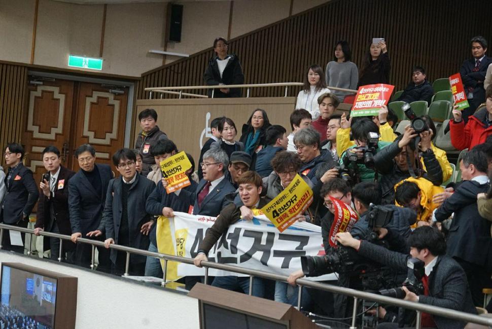 20일 서울시 의회 본회의에서 4인선거구 수정안 통과를 막기 위한 시민단체 회원들이 이들을 내보내려는 시의회 직원들과 몸싸움을 벌이고 있다. 정의당 제공