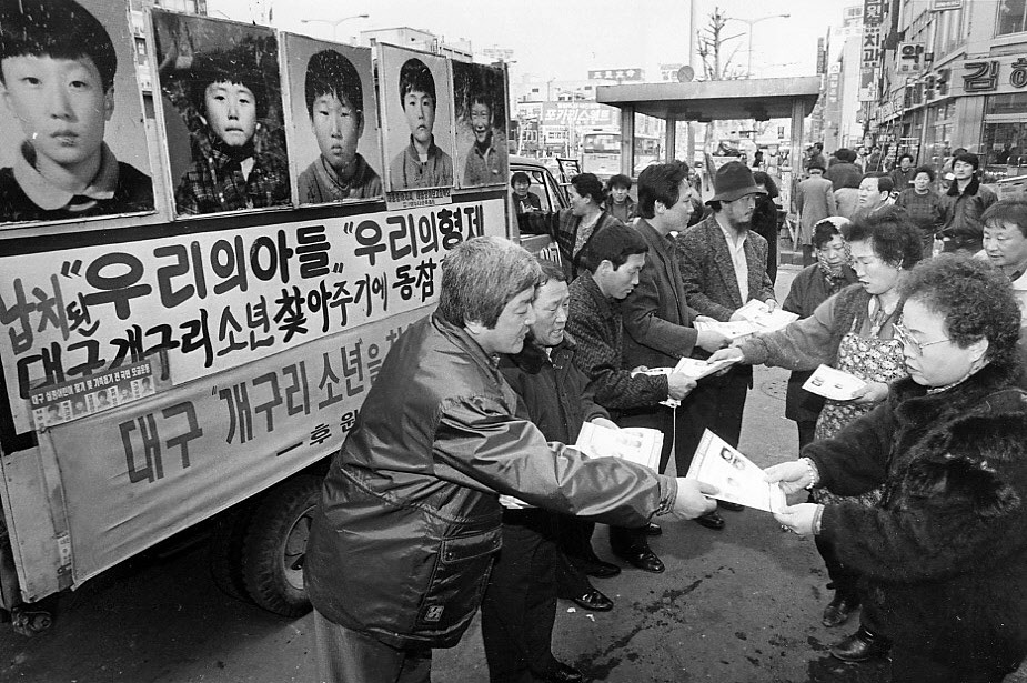 실종된 개구리소년 가족과 개구리소년찾기 후원회 회원들이 서울 종로구 종로5가 동대문시장 입구에서 소년들의 얼굴사진이 들어있는 유인물을 나눠주고 있다. <한겨레> 자료 사진.