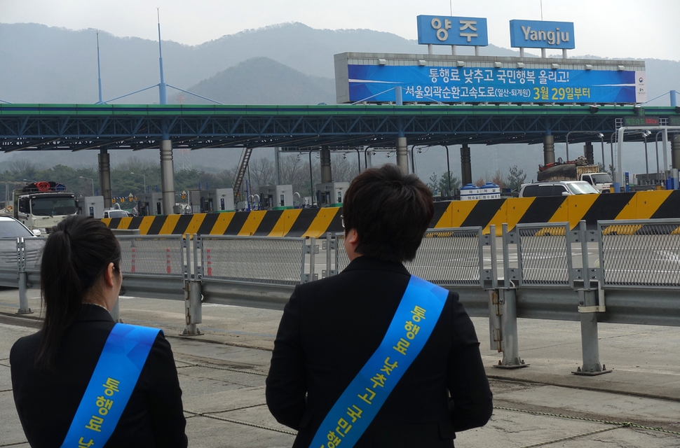 서울고속도로㈜ 직원들이 28일 양주나들목 앞에서 서울외곽순환고속도로 북부구간 통행요금을 29일 0시부터 인하한다는 홍보활동을 벌이고 있다. 박경만 기자