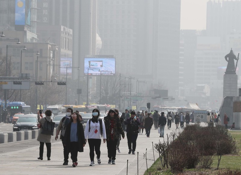 전국 대부분 지역의 미세먼지 수준이 ‘나쁨’을 보인 25일 서울 광화문광장에서 외국인 관광객들이 마스크를 쓴 채 걷고 있다. 백소아 기자 thanks@hani.co.kr