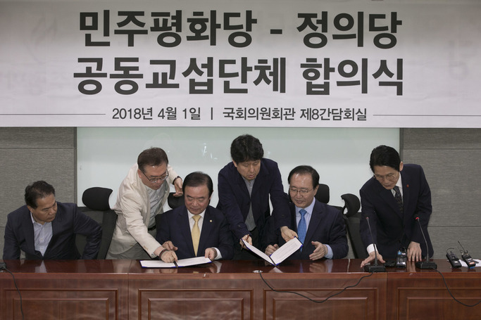 ‘민주평화당-정의당 공동교섭단체 합의식’이 1일 오후 국회 의원회관에서 열려 장병완 민주평화당 원내대표(왼쪽 셋째), 노회찬 정의당 원내대표(오른쪽 둘째)가 참석해 합의문에 서명하고 있다. 김성광 기자 flysg2@hani.co.kr