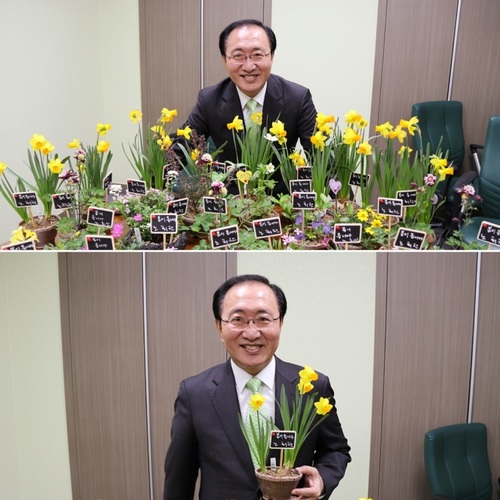 노회찬 정의당 원내대표가 2일 민주평화당과 정의당의 공동교섭단체 ‘평화와 정의의 의원 모임’ 출범을 기념하며 두 당의 의원들에게 선물한 야생화 화분을 들고 웃고 있다. 야생화 화분에는 ‘봄이 옵니다. 노회찬’이라는 문구의 손팻말이 꽂혀 있다. 사진 정의당 제공.