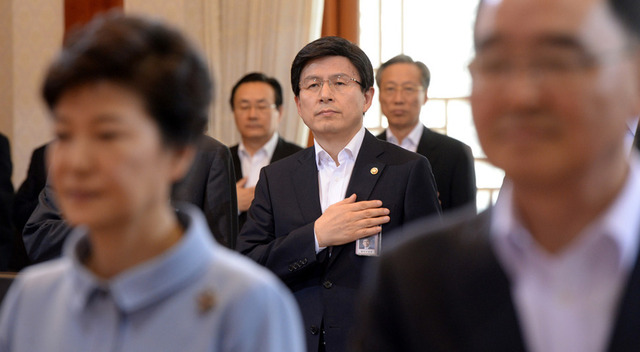 2013년 9월17일 오전 청와대에서 열린 국무회의에서 박근혜 대통령 뒤로 황교안 당시 법무부 장관이 국기에 대한 경례를 하고 있다. 청와대사진기자단