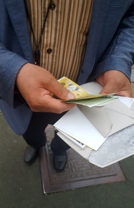 신문사의 불법 경품 제공에 대한 신고포상금이 크게 줄어 신문고시가 유명무실해졌다는 지적이 나오는 가운데,  지난 3일 경기도 고양시의 한 아파트단지 앞에서 한 남성이 길가던 주민에게 “신문 구독을 하면 현금 8만원을 주겠다”며 봉투에서 돈을 꺼내보이고 있다. 독자 제공