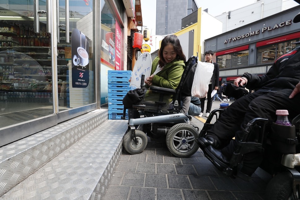 문애린 서울장애인차별철폐연대 사무국장이 11일 오전 장애인 접근성 보장을 요구하며 계단으로 출입이 불가능한 서울 명동 지에스(GS)25 앞에서 시위를 벌이고 있다. 박종식 기자 anaki@hani.co.kr