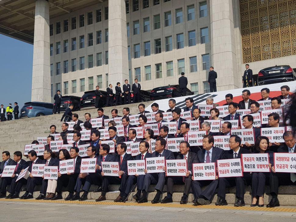 17일 자유한국당 의원들이 국회의사당 본청 계단 앞에 천막본부를 차린 뒤 계단에서 의원총회를 열었다. 의원들이 총회 직전 청와대와 민주당을 규탄하는 손피켓을 들고 있다. 정유경 기자