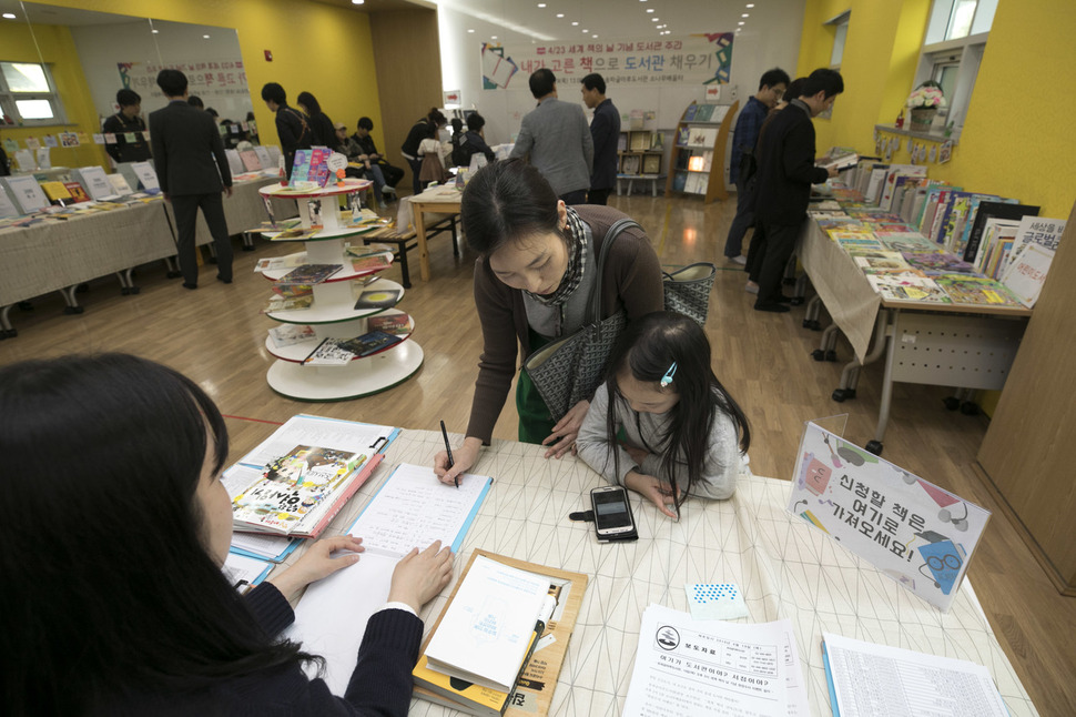 ‘세계 책의 날’을 나흘 앞둔 19일 오후 서울 송파구 송파글마루도서관 1층 소나무배움터에서 ‘내가 고른 책으로 도서관 채우기’ 행사가 열려 정승혜씨(43)와 딸 황아민(8)양이 도서신청을 하고 있다. 김성광 기자