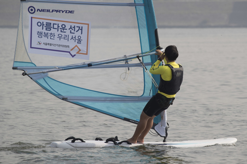 서울시윈드서핑보드연맹 회원들이 20일 오후 서울 광진구 한강공원 뚝섬지구에서 돛에 ‘제7회 전국동시지방선거’ 홍보물을 붙인 채 윈드서핑을 하고 있다. 김성광 기자