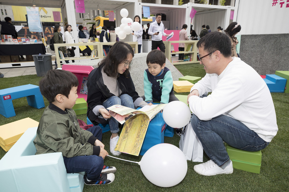 '2018 세계 책과 저작권의 날'을 맞아 22일 오전 서울 종로구 광화문광장에서 '누구나 책 어디서나 책' 행사가 열려 가족이 함께 모여 그림첵을 읽고 있다. 김성광 기자