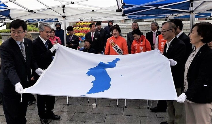 경남도교육청과 시민단체 관계자들이 23일 한반도기를 펼쳐 들고 있다. 왼쪽 앞부터 시계 방향으로 송기민 부교육감, 박종훈 교육감, 김영만 경남평화회의 상임의장, 이경희 ‘일본군 위안부 할머니와 함께 하는 마산·창원·진해 시민모임’ 대표.