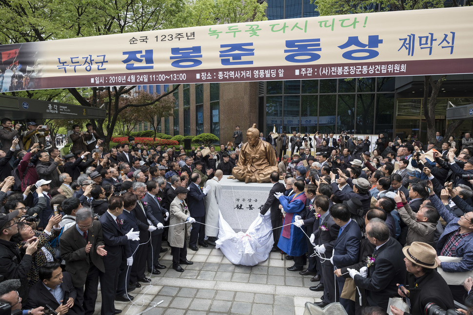 전봉준장군동상건립위원회가 24일 오전 서울 종로구 종각역 5, 6번 출구 사이에서 동상 제막식을 열어 참석자들이 가림막을 제거하고 있다. 김성광 기자