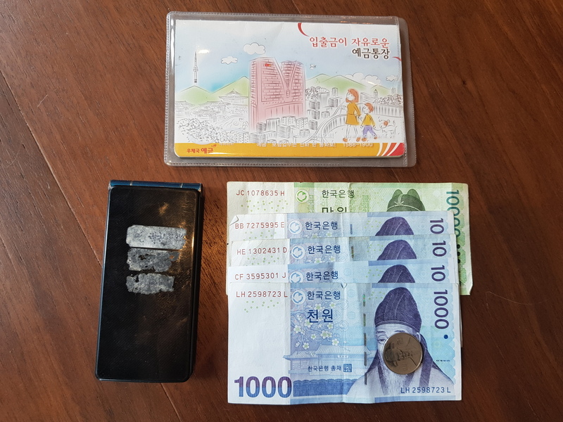 절도 혐의로 선고받은 벌금 150만원을 내지 못해 노역장에 유치됐다 심부전이 악화돼 숨진 김아무개씨가 남진 유품. 요금을 미납해 끊긴지 오래인 구형 폴더폰과 기초생활수급비를 받기 위해 개설한 통장, 노역장에 갖고 들어간 현금 1만4100원이 전부다. 김씨는 심부전 수술을 받은지 나흘 만에 노역장에 입감됐고, 그로부터 이틀 뒤에 숨을 거뒀다. 김씨 유가족 제공