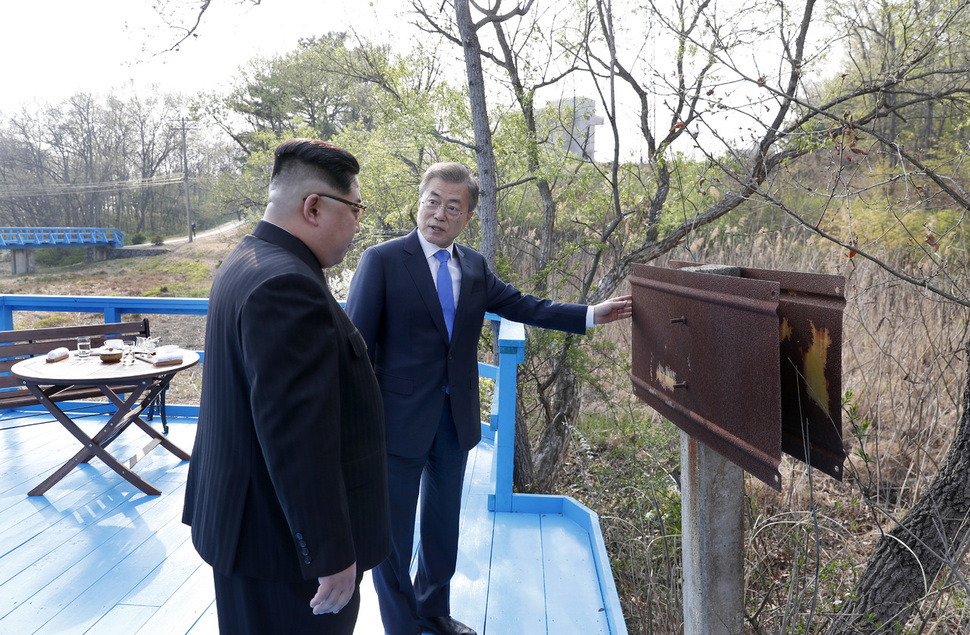 문재인 대통령과 김정은 북한 국무위원장이 27일 오후 판문점 내 '도보다리'에서 군사분계선 표식물을 살펴보며 대화를 하고 있다. 한국공동사진기자단