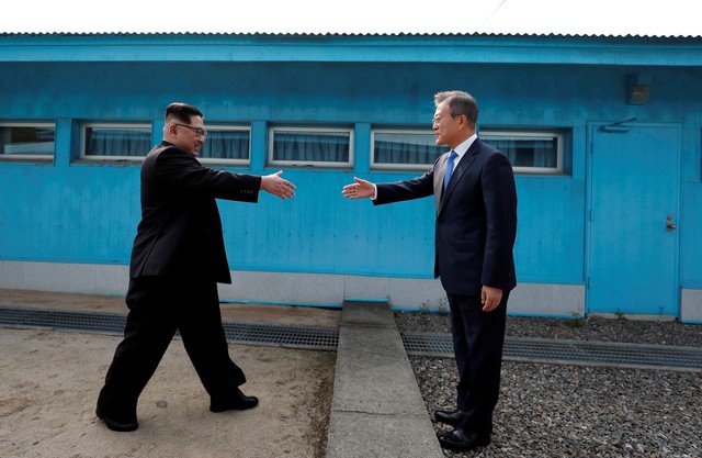 문재인 대통령과 김정은 국무위원장이 군사분계선에서 처음 만나 악수를 하고 있다.