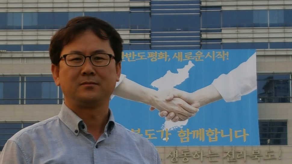 남북정상회담이 열린 지난 27일 한반도기가 내걸린 전북도청 앞에 홍희표씨가 서 있다. 박임근 기자