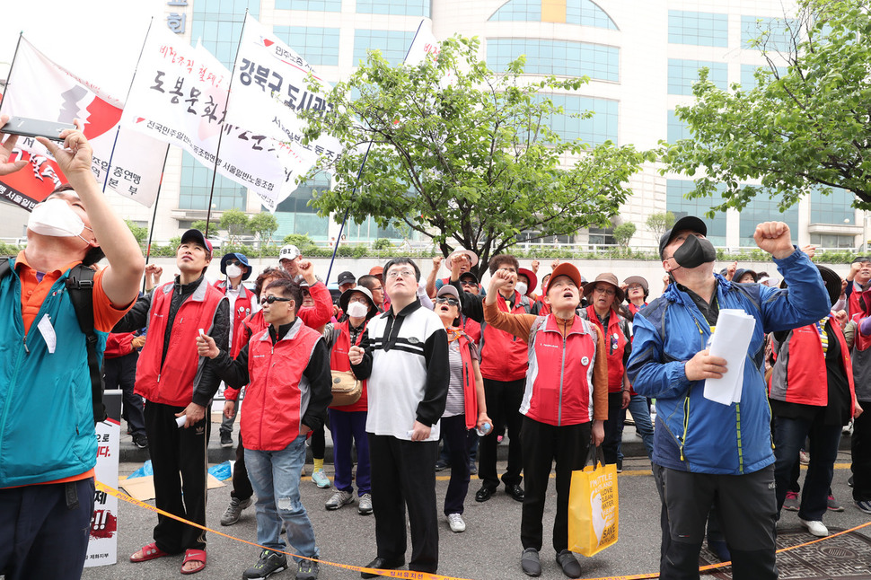 1일 오전 서울 관악구 탠디 본사 앞에서 열린 "노동절128주년 제화노동자 피빨아먹는 악덕업체 탠디 규탄 집회"에서 참가자들이 점거 농성중인 동료들을 바라보며 투쟁을 외치고 있다. 백소아 기자