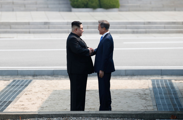 2018 남북정상회담이 열린 27일 문재인 대통령과 김정은 북한 국무위원장이 군사분계선을 넘어 판문점 북측 지역에서 인사를 나누고 있다. 판문점/한국공동사진기자단