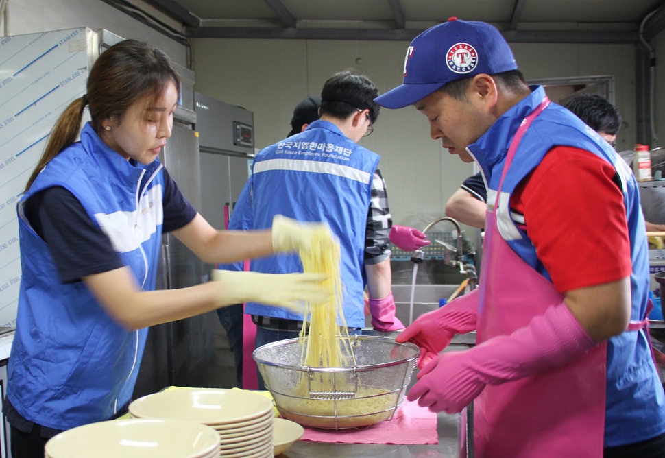 한국GM 군산공장 봉사자 모임인 넝쿨봉사회와 비영리법인 지역경제교류회 회원들이 12일 전북 군산시 대야면 중증장애인 직업재활시설을 찾아 짜장면을 만들고 있다. 넝쿨봉사회원들은 퇴직 후에도 이곳을 찾아 봉사활동을 지속한다. 연합뉴스