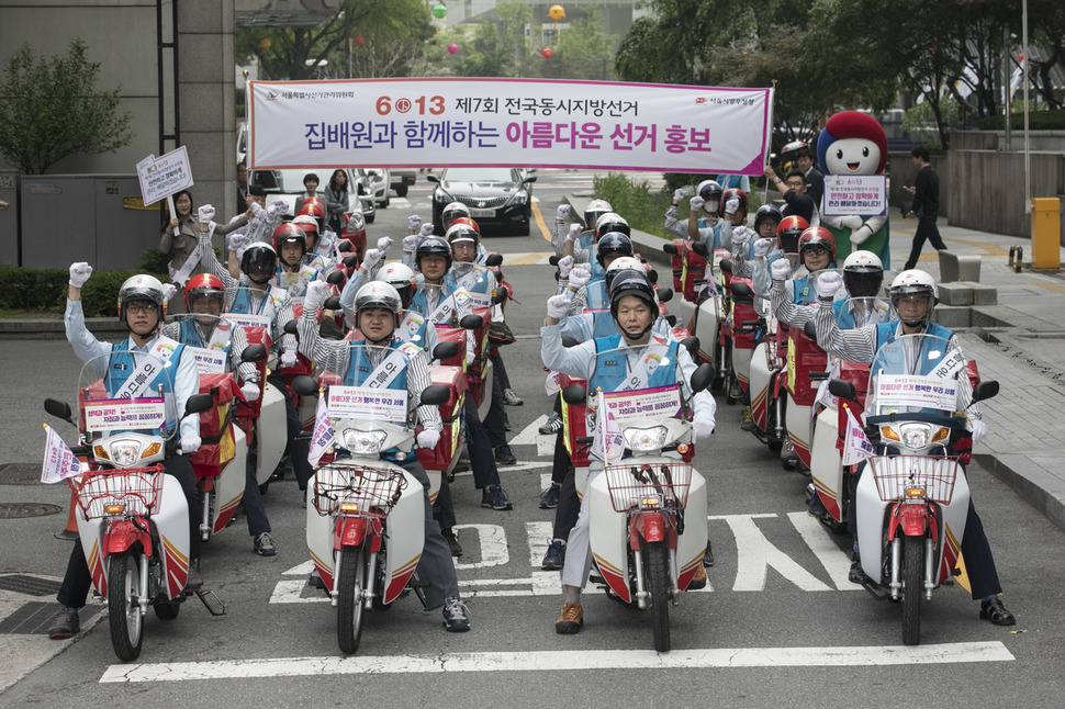 ‘6.13 지방선거’를 30일 앞둔 14일 오전 서울 종로구 광화문우체국에서 ‘집배원과 함께하는 아름다운 지방선거 홍보단 발대식’이 열려 집배원들이 사전투표 등을 안내하는 스티커와 깃발이 부착된 오토바이를 탄 채로 화이팅을 외치고 있다. 김성광 기자