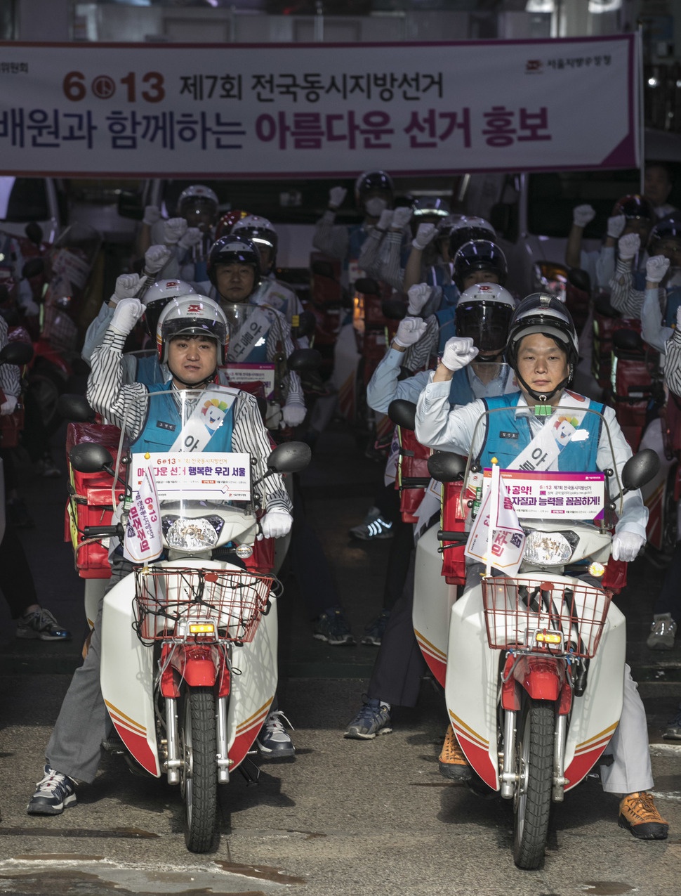 ‘6.13 지방선거’를 30일 앞둔 14일 오전 서울 종로구 광화문우체국에서 ‘집배원과 함께하는 아름다운 지방선거 홍보단 발대식’이 열려 집배원들이 사전투표 등을 안내하는 스티커와 깃발이 부착된 오토바이를 탄 채로 화이팅을 외치고 있다. 김성광 기자