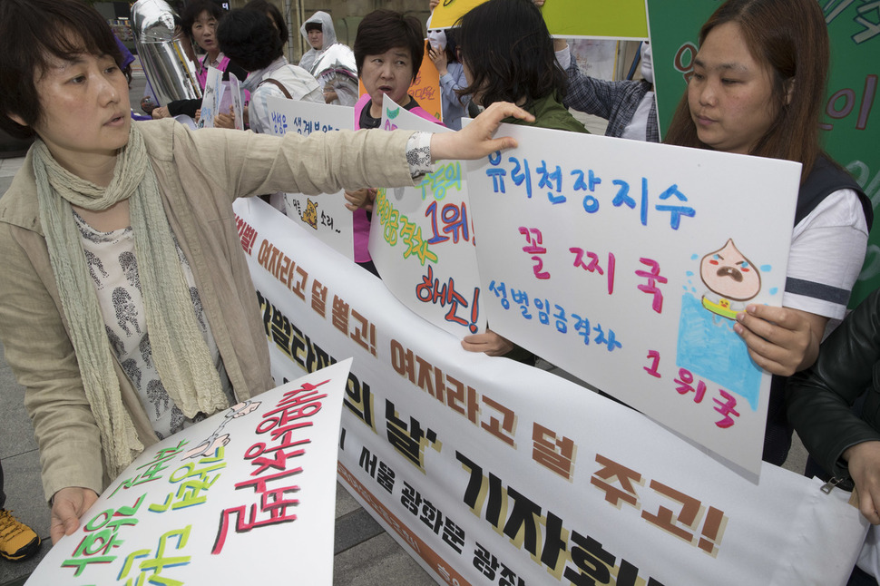 ‘제2회 임금차별타파의 날’인 18일 오전 서울 종로구 광화문광장에서 한국여성노동자회 회원과 전국여성노동조합 조합원들이 기자회견에 참석해 여성들이 겪고 있는 고용형태 및 임금 차별에 대한 내용이 적힌 손팻말을 들고 있다. 김성광 기자