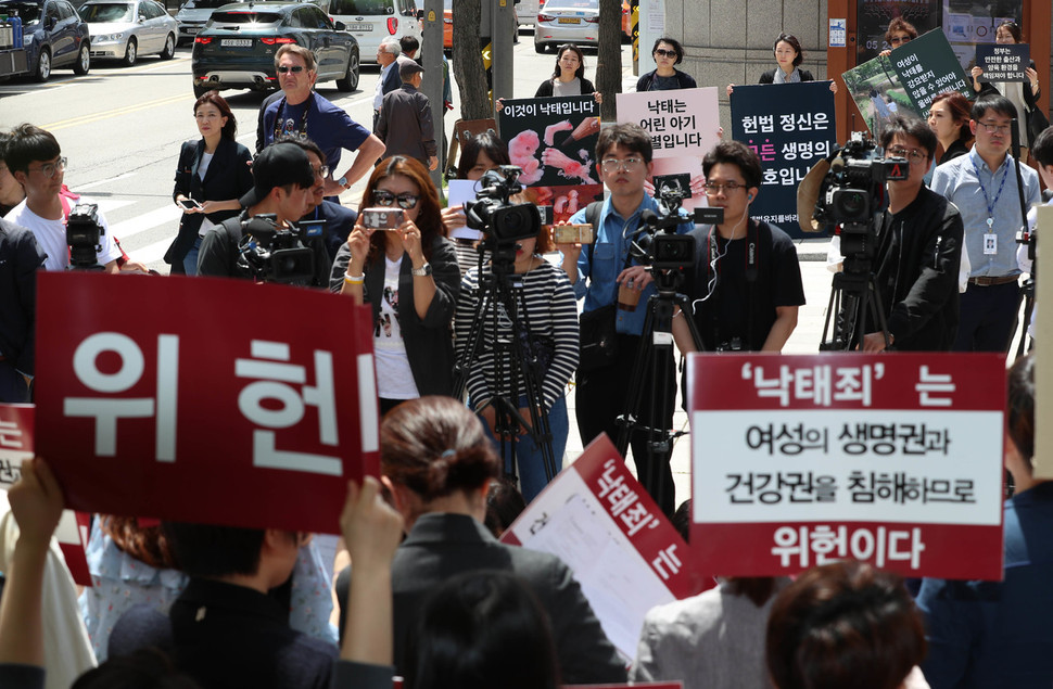 낙태를 처벌하는 형법 조항(제269·270조)의 위헌 여부를 가리는 공개변론이 열린 24일 서울 재동 헌법재판소 앞에서 ‘모두를 위한 낙태죄폐지 공동행동’ 소속 단체 회원들이 기자회견을 열어 ‘낙태죄 위헌 판결’을 촉구하는 동안, 낙태죄 유지를 원하는 단체 회원들이 건너편에서 팻말 시위를 하고 있다. 김정효 기자 hyopd@hani.co.kr