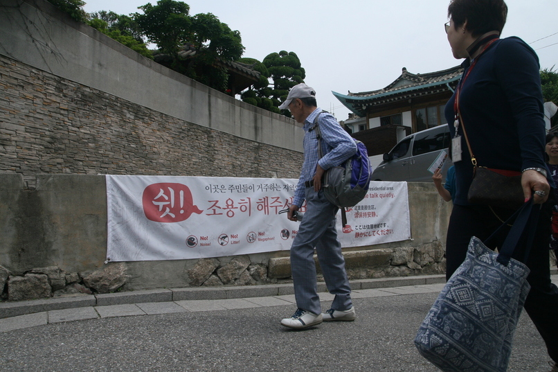 부처님오신날인 지난 5월22일 오전. 관광객들이 ‘조용히 해달라’는 문구가 적힌 펼침막을 바라보며 서울 종로구 북촌 ‘가회동 골목길’을 지나고 있다.