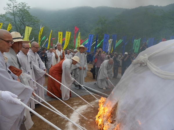 30일 강원도 고성 건봉사에서 열린 조오현 스님 다비식에서 스님들이 연화대에 불을 붙이고 있다. 사진 조현 종교전문기자