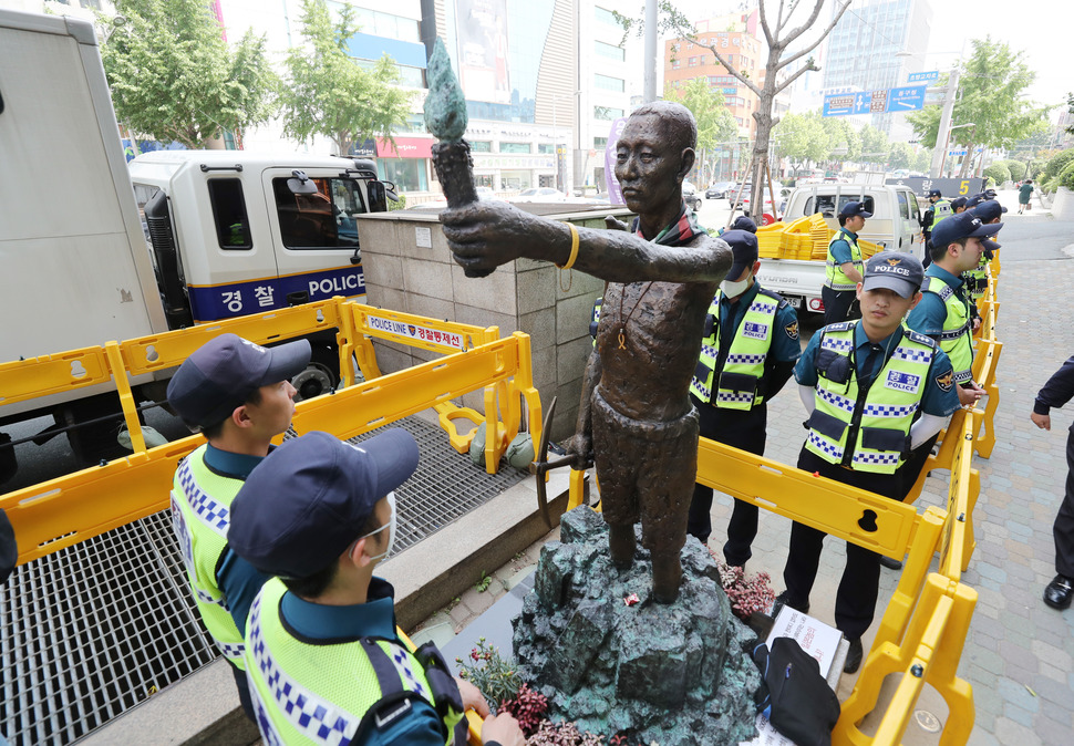 30일 오후 부산 동구 초량동 일본총영사관 인근 인도에 놓여 있는 강제징용노동자상 앞에 강제철거에 사용될 지게차가 놓여 있고 시민단체는 강체철거에 대비해 농성을 펼치고 있다. 부산 동구는 오는 31일 인도 위 노동자상을 강제철거한다고 예고했다. 부산/연합뉴스
