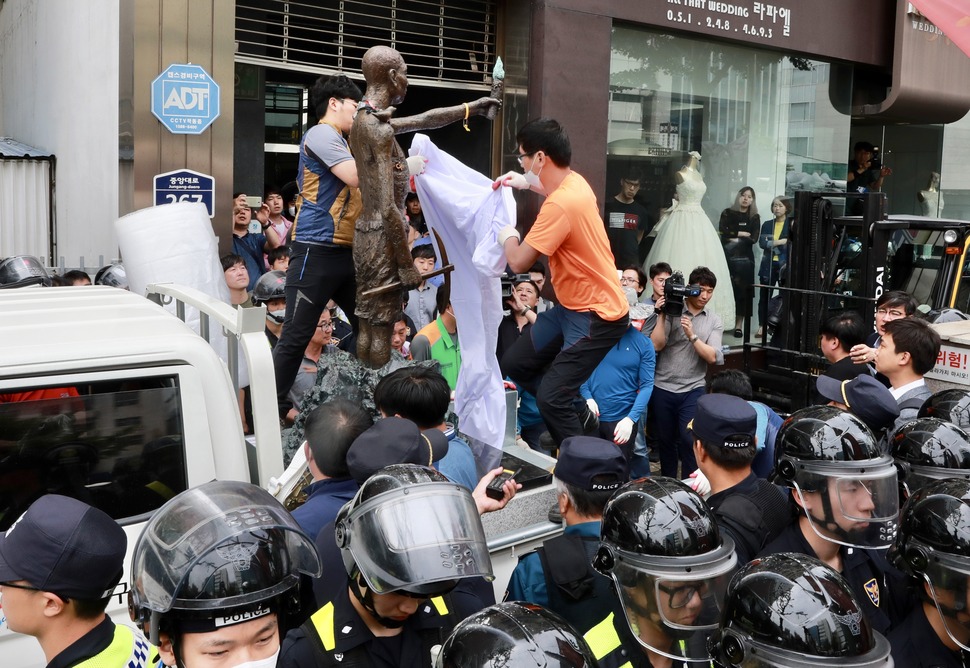 31일 오후 부산 동구청 관계자들이 지게차와 트럭을 이용해 부산 일본총영사관 인근 인도 앞에 놓여 있는 강제징용노동자상을 행정대집행을 통해 강제철거하고 있다. 부산/연합뉴스