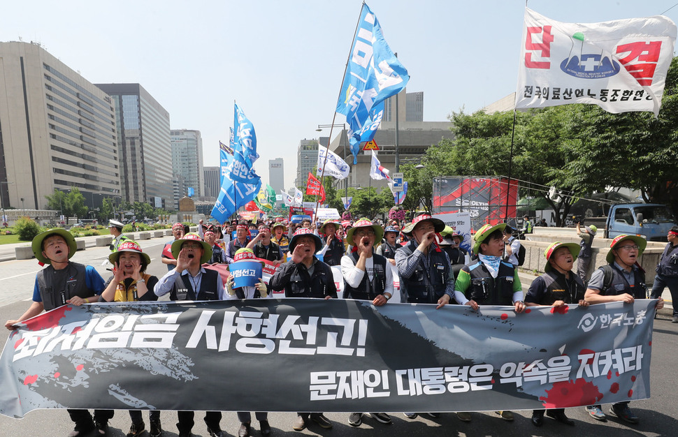 5일 오전 서울 종로구 세종로공원 앞에서 열린 최저임금법 개악 폐기를 위한 한국노총 결의대회를 마친 참석자들이 청와대로 행진 하며 정부서울청사를 향해 최저임금법 개정안 폐기를 촉구하고 있다. 신소영 기자