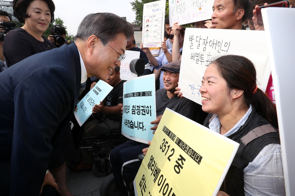 문재인 대통령과 김정숙 여사가 8일 오전 서울 종로구 청와대 인근 한 투표소에서 6·13 지방선거 및 국회의원 재보궐선거 사전투표를 마치고 장애인 참정권을 요구하는 장애인단체 회원들과 대화를 나누고 있다. 청와대사진기자단