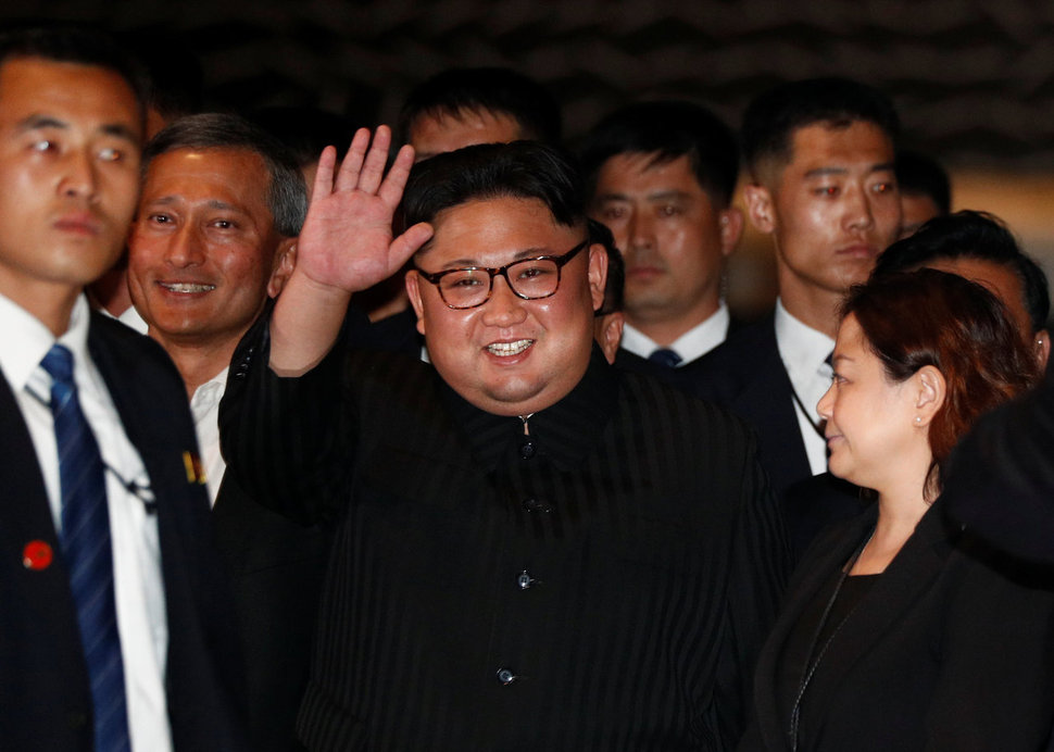 김정은 북한 국무위원장이 11일 밤 싱가포르 마리나베이 샌즈 호텔에서 관광객 등 주변 사람들을 향해 손을 들며 미소 짓고 있다. 사진 연합뉴스