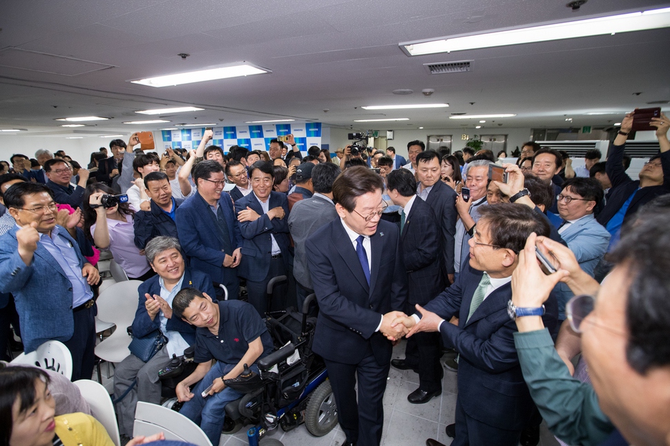 지상파 방송 3사의 출구조사 결과 발표 직후 13일 오후 6시께 캠프 상황실을 찾은 이재명 더불어민주당 경기도지사 후보가 지지자들의 환호를 받으며 악수를 하고 있다. 이재명 캠프 제공