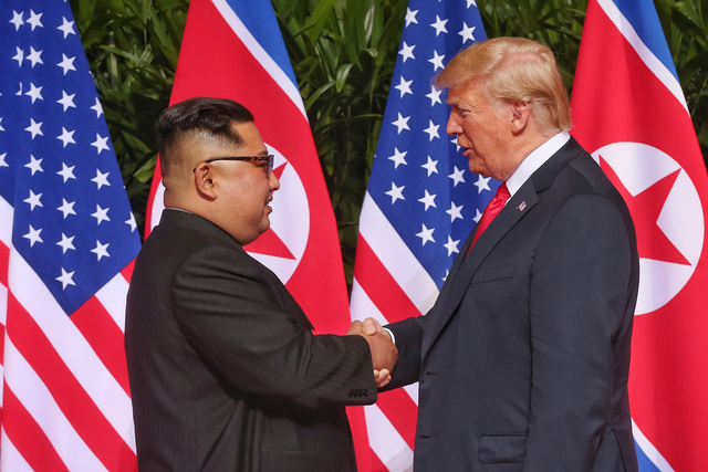 김정은 북한 국무위원장과 도널드 트럼프 미국 대통령이 12일(현지시각) 싱가포르 카펠라 호텔에서 만나 악수하고 있다. 케빈 림/스트레이츠 타임스 제공