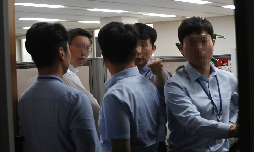 19일 오후 검찰이 이명박 정부 시절 국가정보원이 양대 노총 중심의 노동운동을 분열시키려 공작을 벌인 정황이 포착돼 정부세종청사 고용노동부에 대해 압수수색을 하자 노사협력정책관 직원들이 당황한 표정을 짓고 있다. 세종/연합뉴스