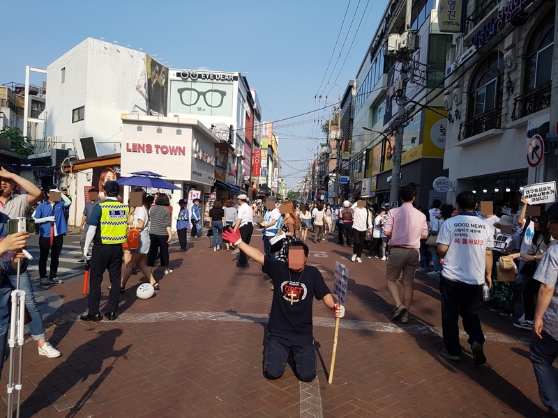 23일 오후 대구 중구 동성로6길에서 기독교 신자가 무릎을 꿇고 무언가를 외치고 있다.